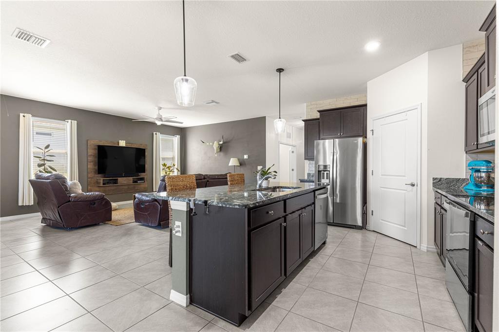 6233 Southwest 89th St Road Ocala, FL 34476 - Photo 7 of 39 a kitchen with stainless steel appliances granite countertop a sink a stove and a refrigerator