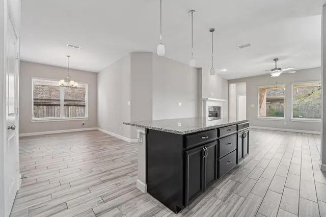 a kitchen with stainless steel appliances kitchen island granite countertop a stove a sink and a refrigerator