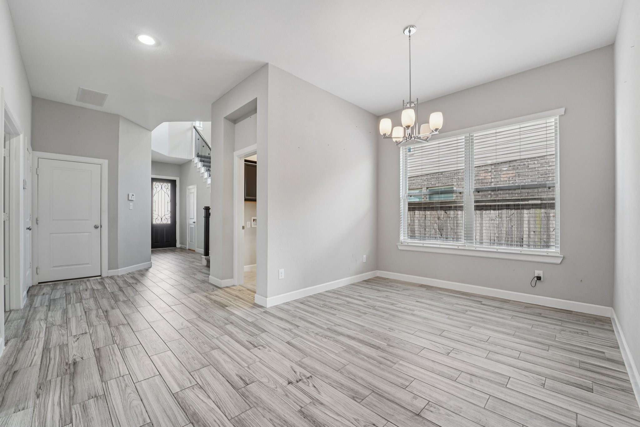 19751 Shinnery Ridge Court Cypress, TX 77433 - Photo 11 of 43 a view of a room with wooden floor chandelier and windows