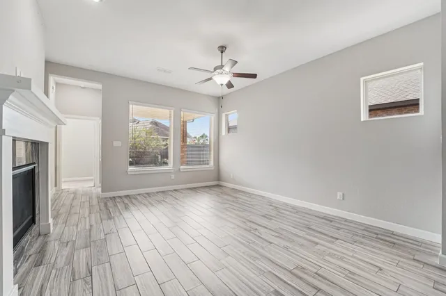 a view of a room with wooden floor chandelier and windows