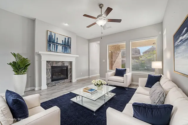 a living room with furniture fireplace and a large window