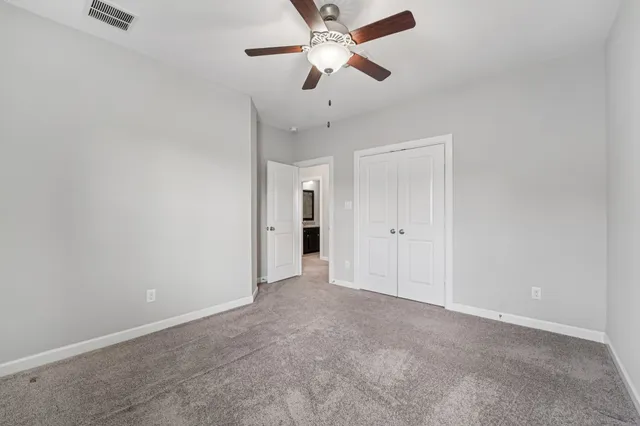 a view of an empty room with a ceiling fan