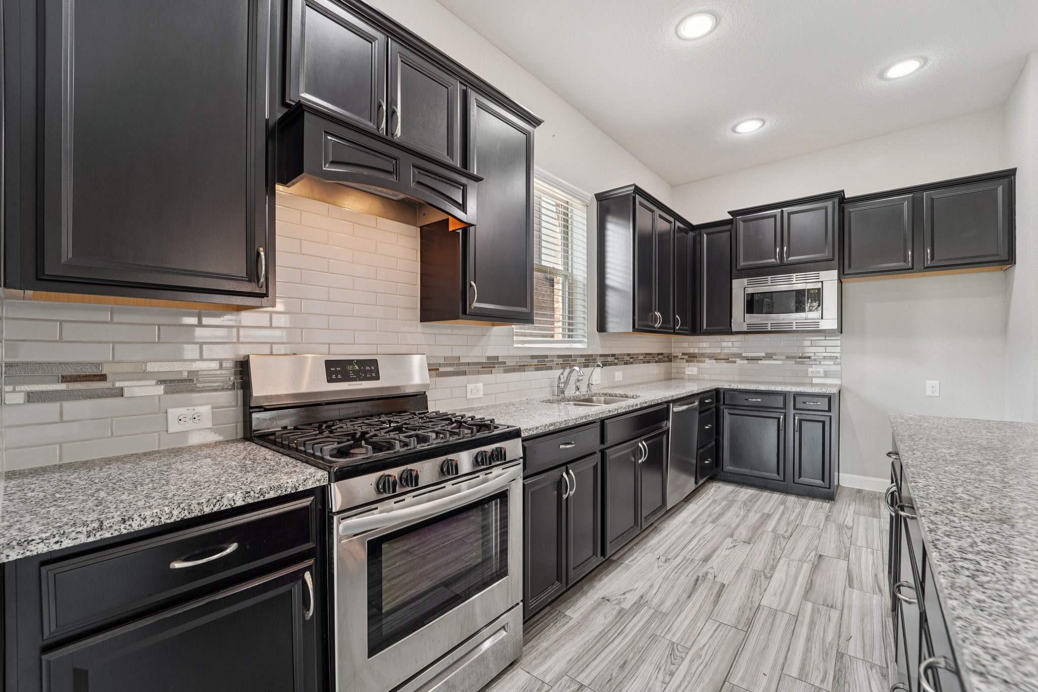 19751 Shinnery Ridge Court Cypress, TX 77433 - Photo 7 of 43 a kitchen with stainless steel appliances granite countertop wooden cabinets stove top oven and sink