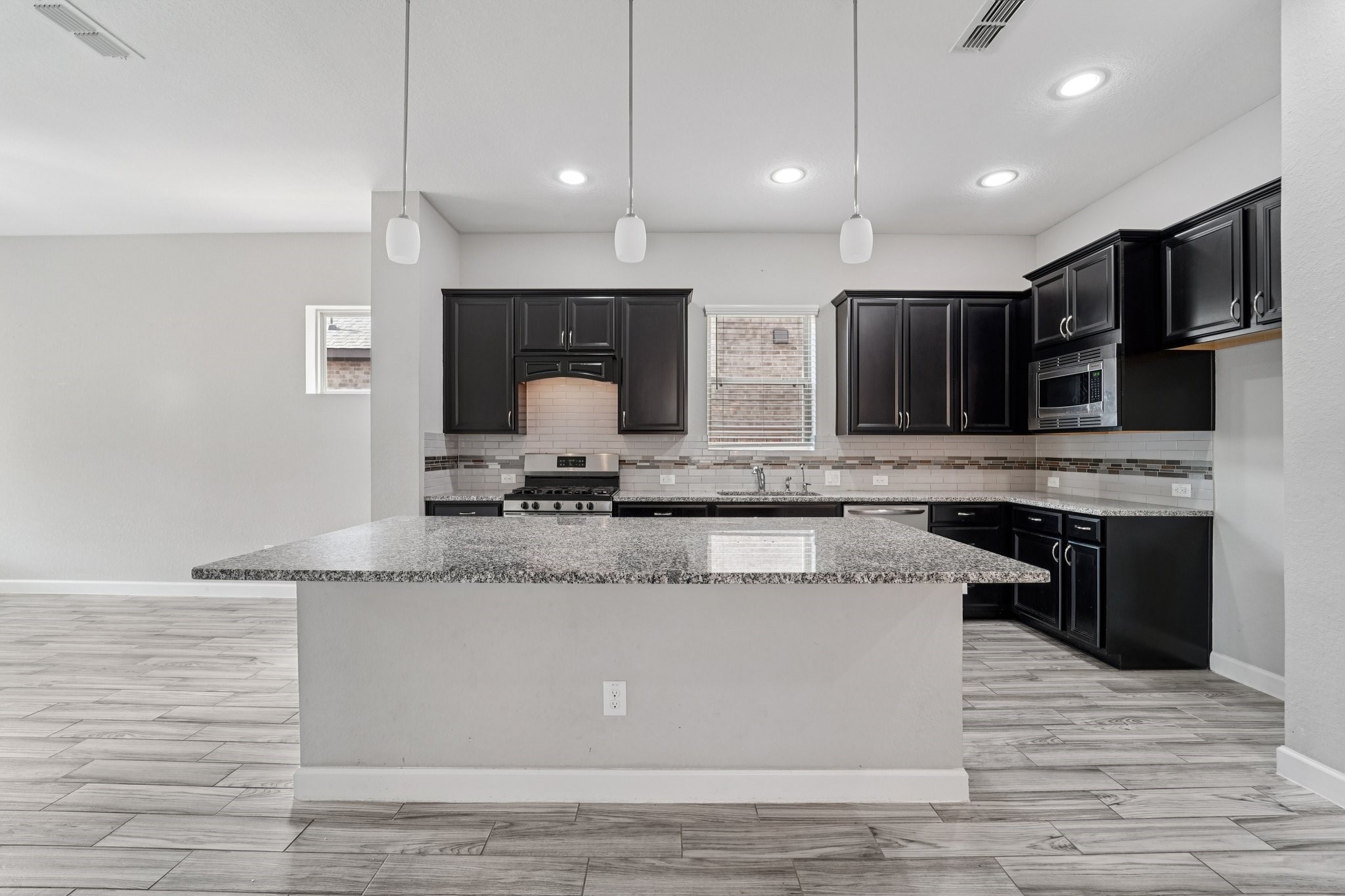 19751 Shinnery Ridge Court Cypress, TX 77433 - Photo 8 of 43 a large kitchen with stainless steel appliances granite countertop a stove a sink and a microwave
