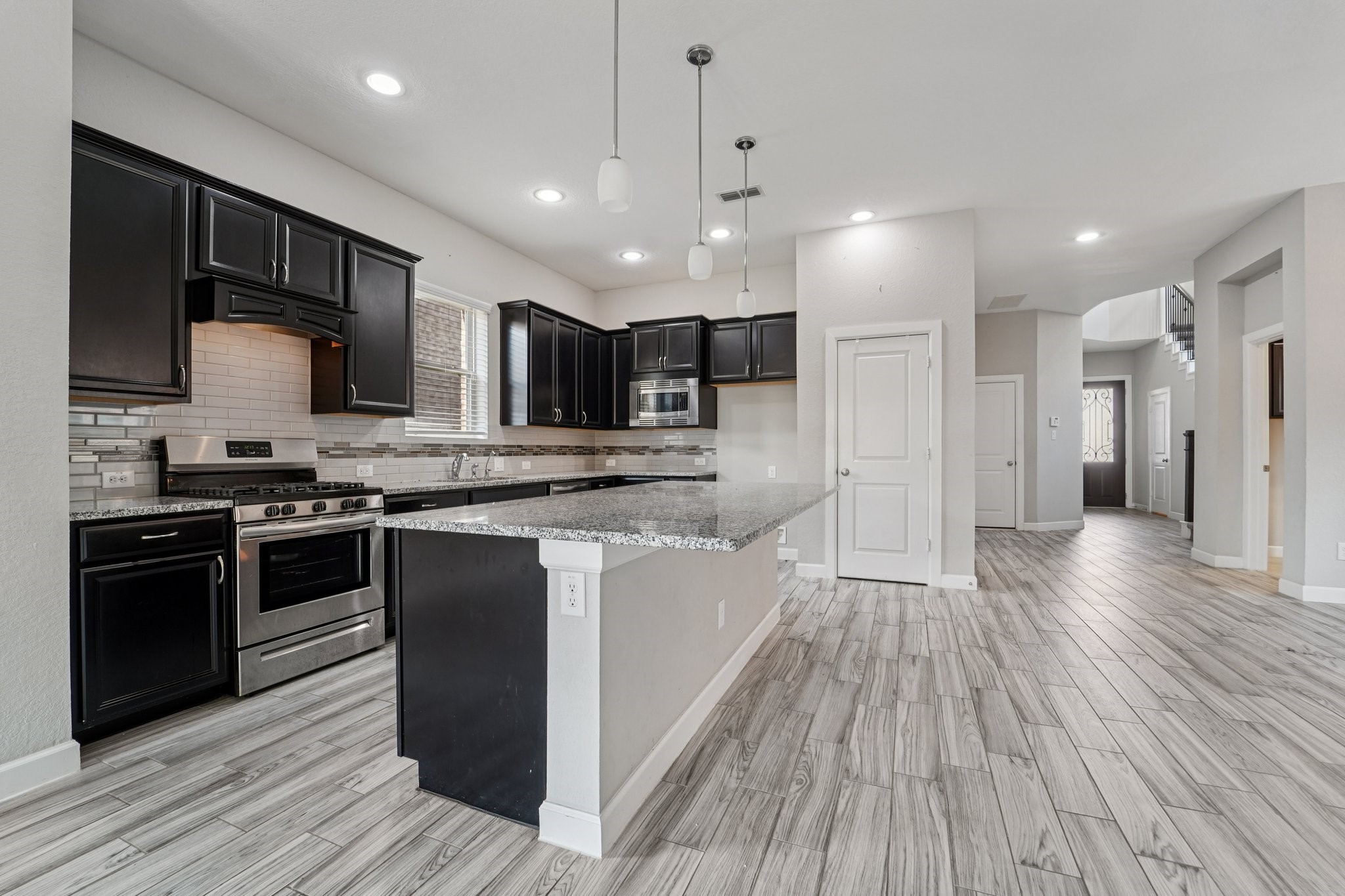 19751 Shinnery Ridge Court Cypress, TX 77433 - Photo 9 of 43 a kitchen with stainless steel appliances kitchen island granite countertop a stove a sink and a refrigerator