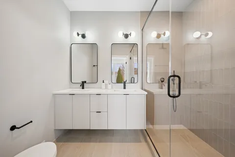 a bathroom with a double vanity sink mirror and shower