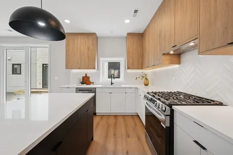 a kitchen with a sink stainless steel appliances cabinets and a window