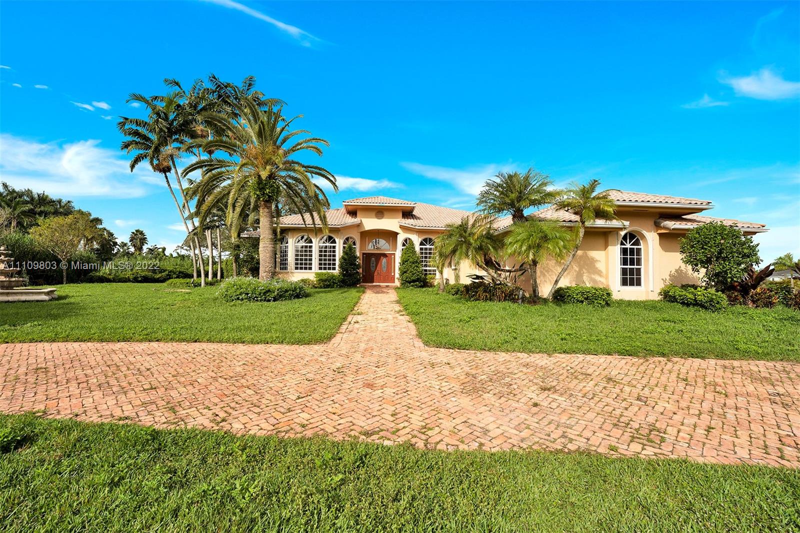 5879 Southwest 178th Avenue Southwest Ranches, FL 33331 - Photo 5 of 27 a view of a white house with a big yard and potted plants