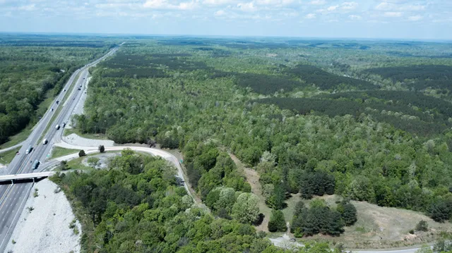 an aerial view of residential houses with outdoor space and trees