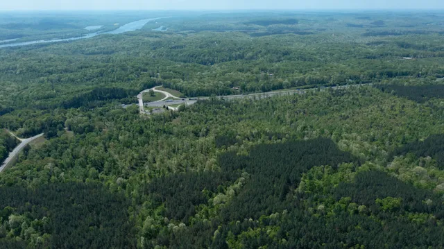 an aerial view of residential house with outdoor space and trees all around