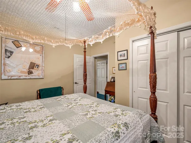 a bed sitting in a bedroom next to a lamp