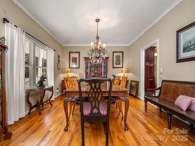 a view of a dining room with furniture a chandelier and wooden floor