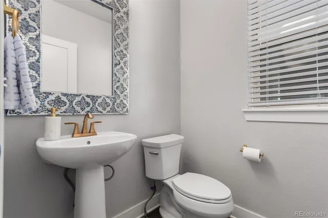 a bathroom with a sink toilet and mirror