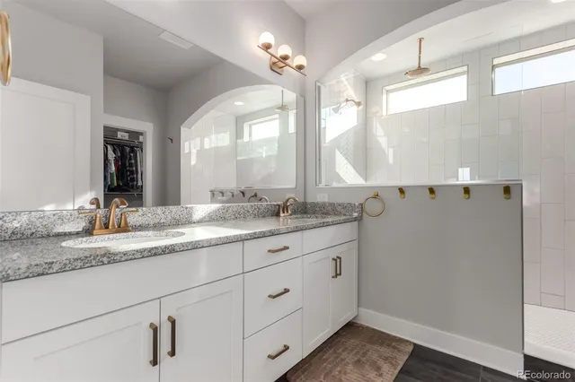 a bathroom with a granite countertop sink and a mirror