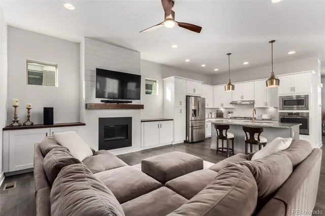a living room with furniture kitchen and a flat screen tv