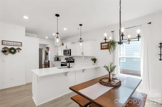 a kitchen with kitchen island white cabinets and refrigerator