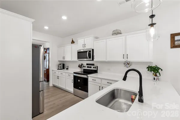 a kitchen with stainless steel appliances granite countertop a sink a stove and a refrigerator
