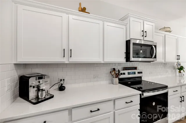 a kitchen with stainless steel appliances granite countertop a sink a stove and cabinets