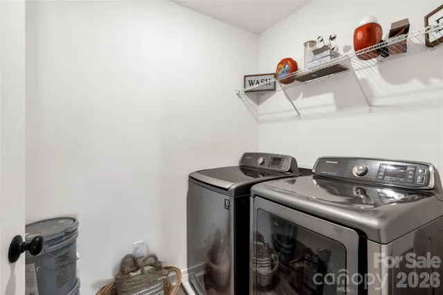 a spacious bedroom with a bed a chandelier and a window