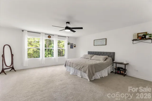 a spacious bedroom with a bed and a flat screen tv