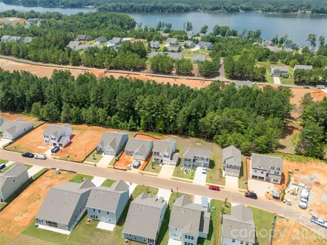 an aerial view of residential houses with outdoor space and parking