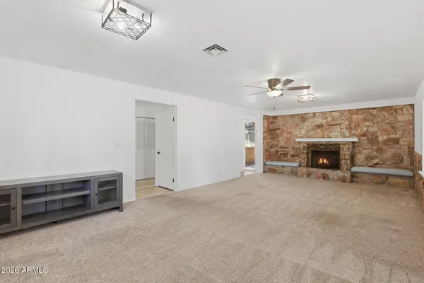 an empty room with windows and fan