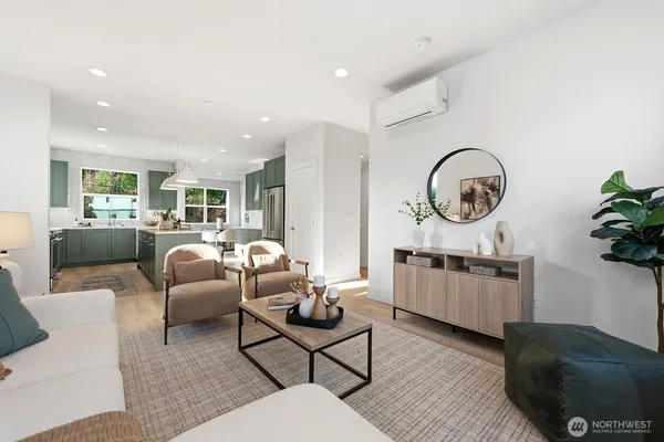 a living room with furniture a rug kitchen view and a window