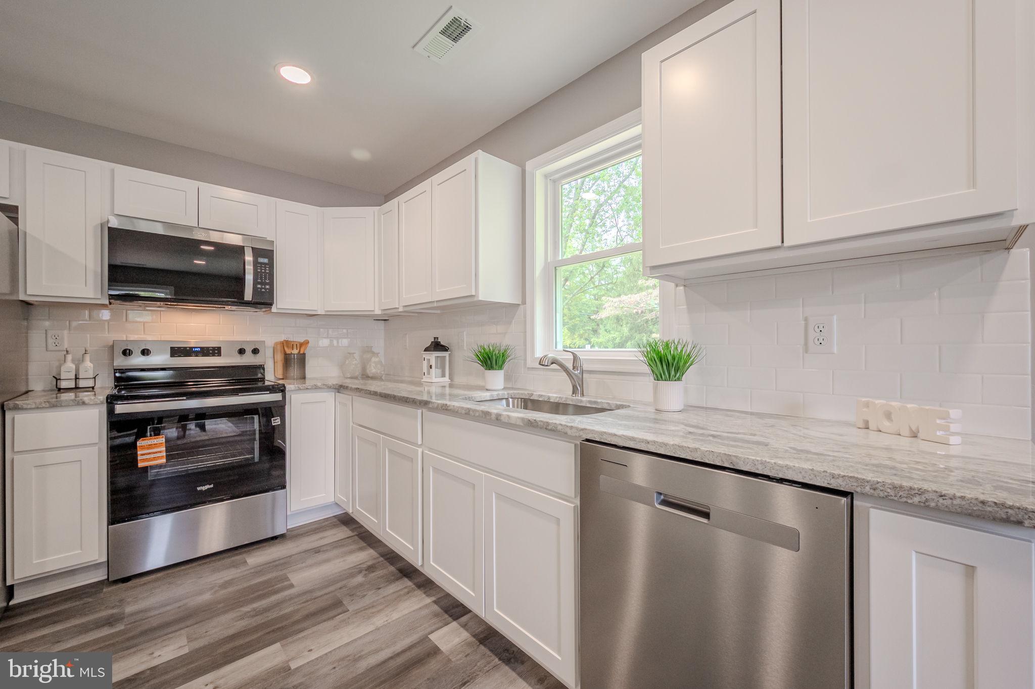 23110 Old Fairlee Road Chestertown, MD 21620 - Photo 11 of 29 a kitchen with kitchen island granite countertop a sink cabinets and stainless steel appliances