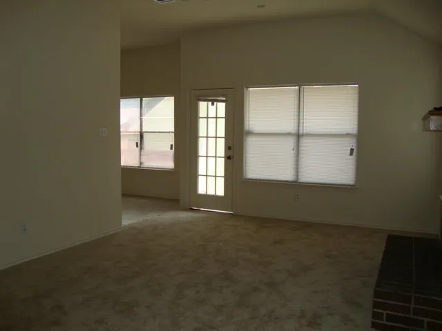 an empty room with a empty space and windows