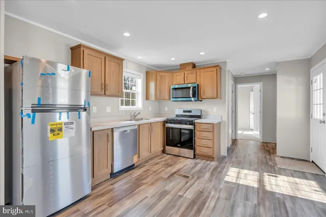 a kitchen with refrigerator cabinets and wooden floor
