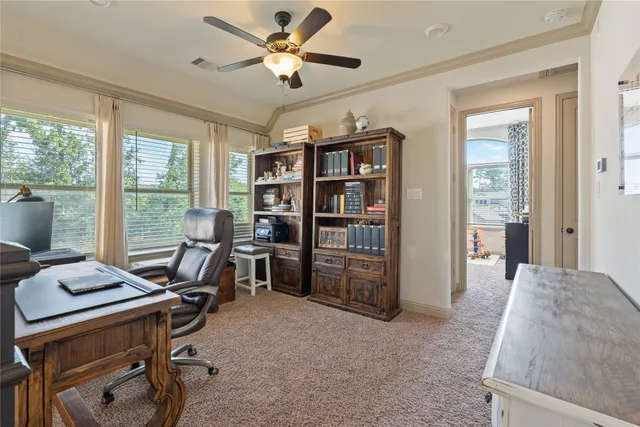 a view of a workspace with furniture and a window
