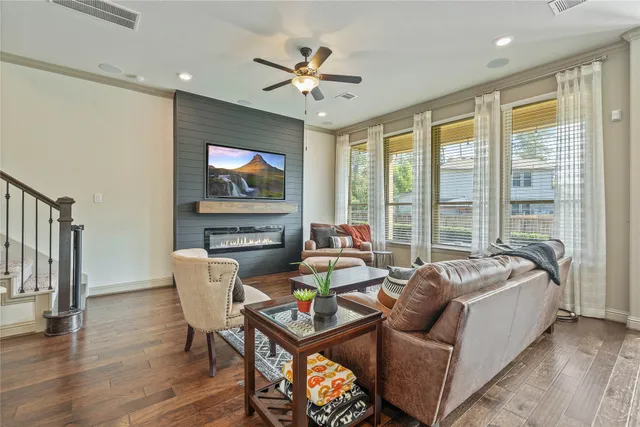 a living room with furniture a floor to ceiling window and a flat screen tv