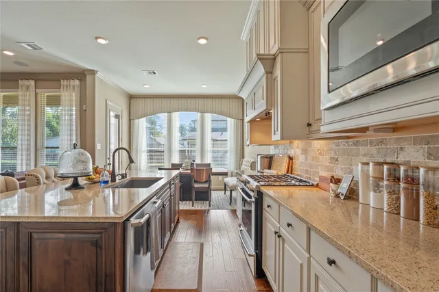 a kitchen with sink stove top oven and cabinets