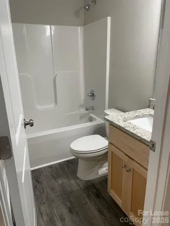 a bathroom with a granite countertop toilet a sink and a bathtub