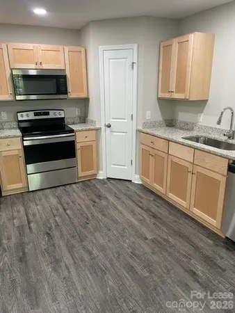 a kitchen with stainless steel appliances granite countertop a stove and a microwave