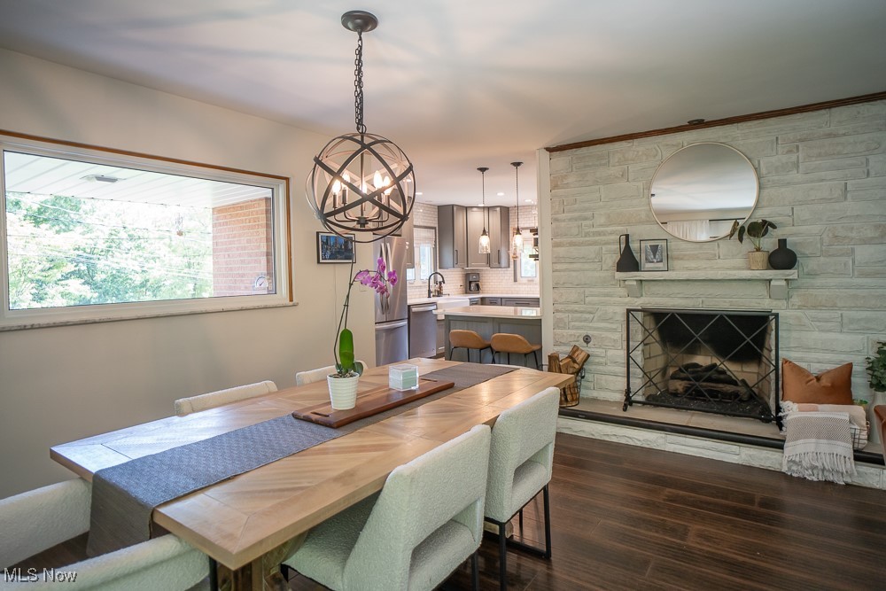 8283 Montello Road Independence, OH 44131 - Photo 28 of 41 Dining space featuring a stone fireplace, a notable chandelier, and dark hardwood / wood-style flooring