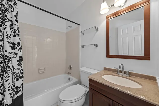 a bathroom with a granite countertop sink a toilet a mirror a vanity and shower