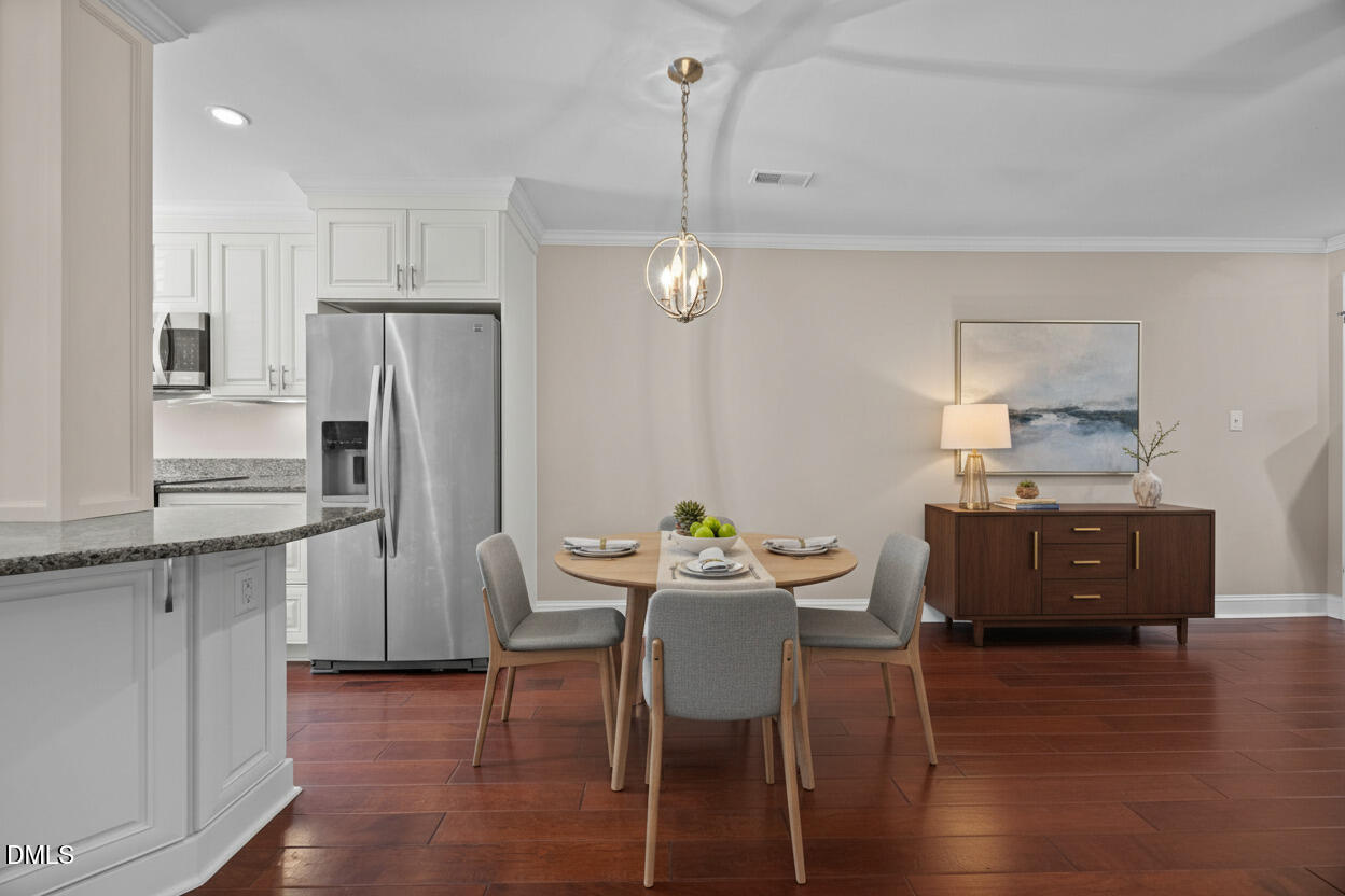 5530 Forest Oaks Drive Raleigh, NC 27609 - Photo 4 of 12 a kitchen with stainless steel appliances a dining table chairs refrigerator and sink