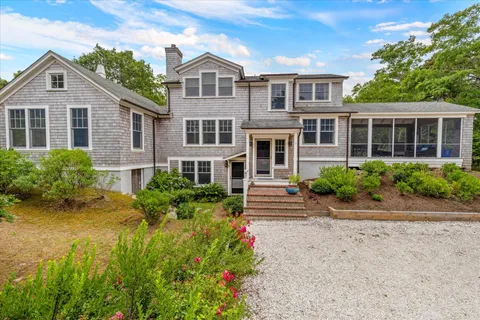 a front view of a house with plants and windows
