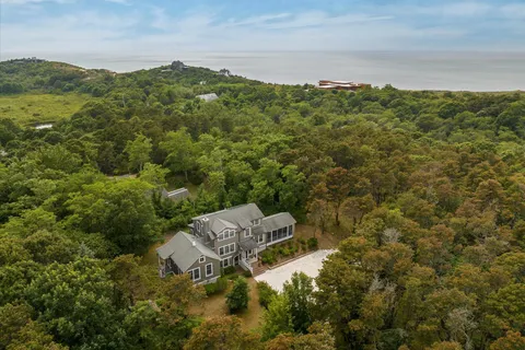 a view of a hallway to a livingroom with wooden floor and furniture