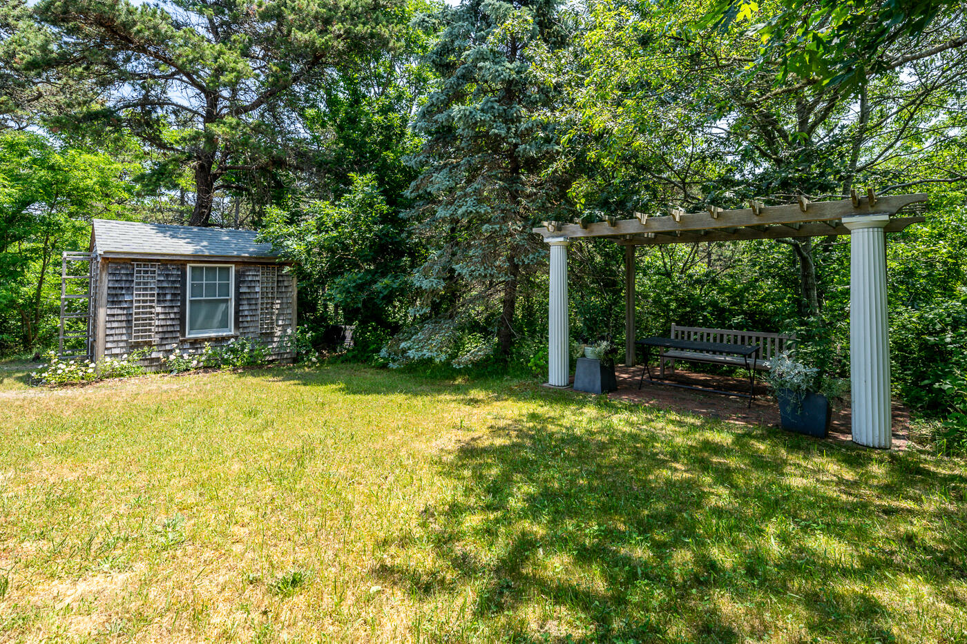 9 Towhee Lane Truro, MA 02666 - Photo 54 of 62 a backyard of a house with swimming pool and large trees
