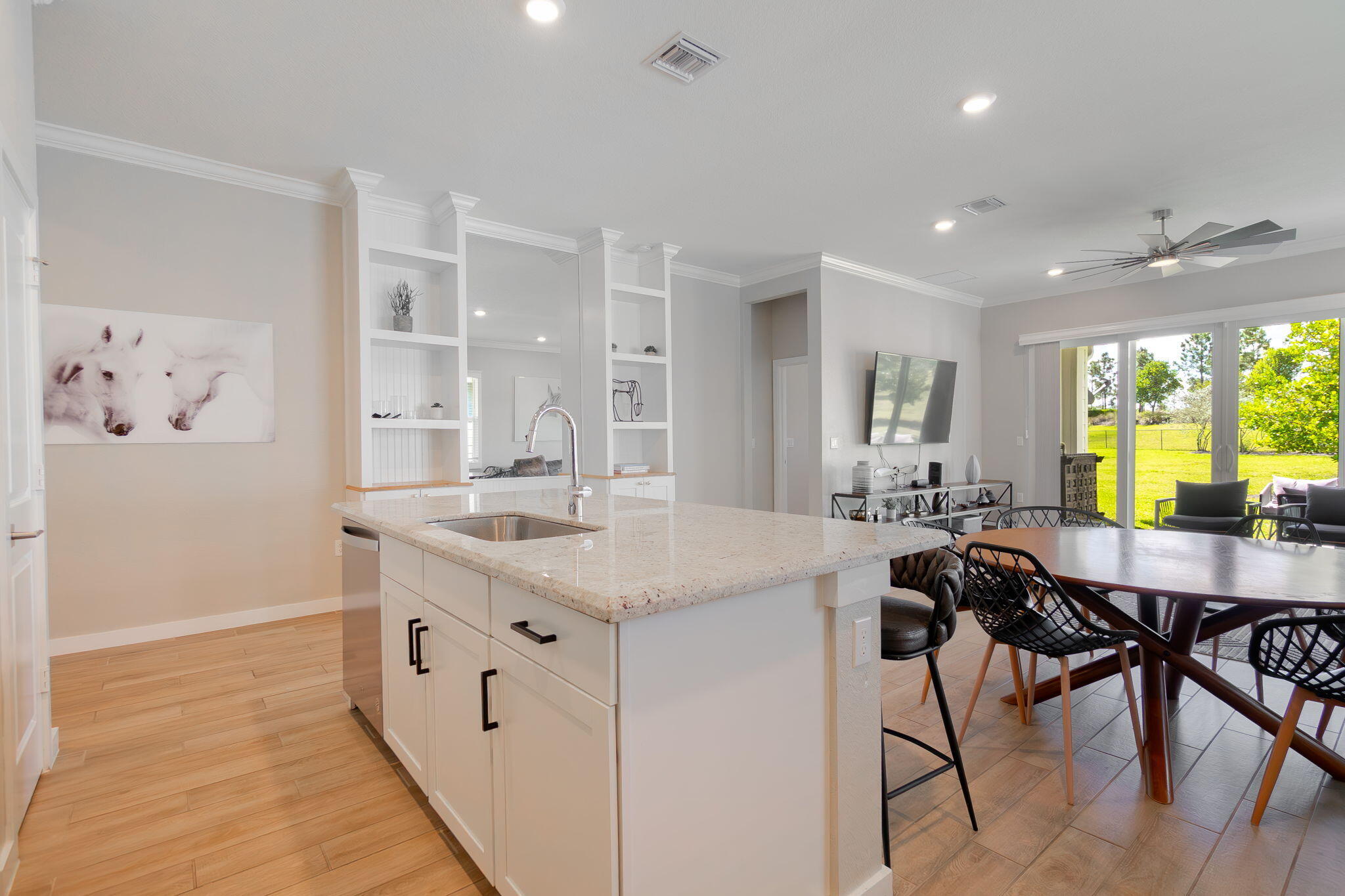 19546 Weathervane Way Loxahatchee, FL 33470 - Photo 17 of 63 a kitchen with stainless steel appliances kitchen island a table chairs in it and white cabinets