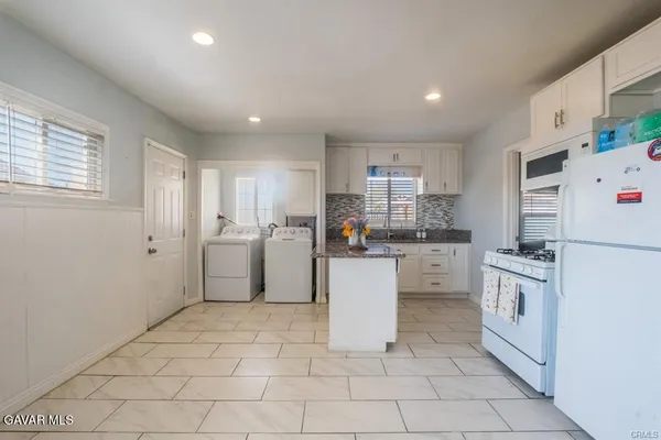 a kitchen with white cabinets and white appliances