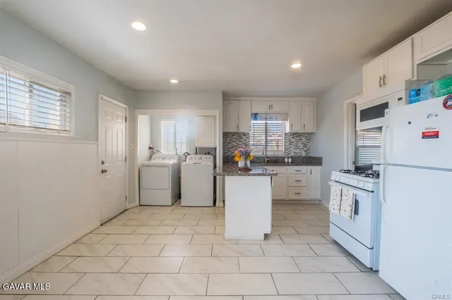 a kitchen with white cabinets and white appliances