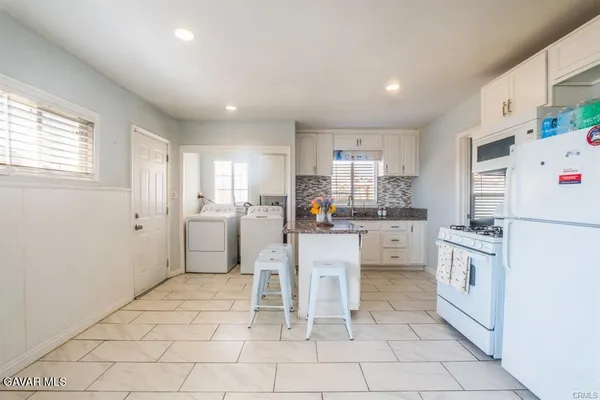 a kitchen with white cabinets and white appliances