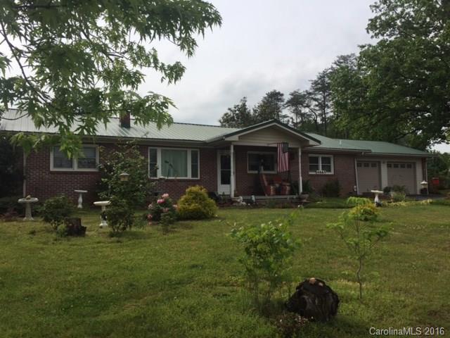 4665 Highway 9 Mill Spring, NC 28756 - Photo 1 of 12 a front view of a house with a garden