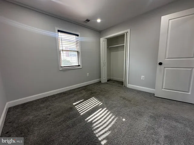 a view of a hallway with wooden floor and closet area