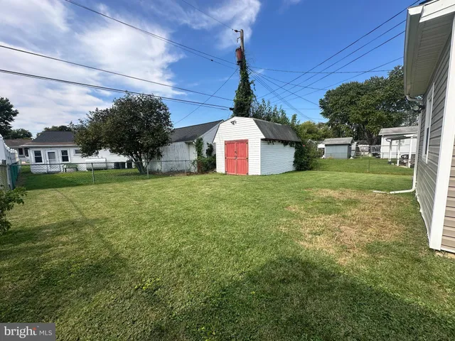 a front view of a house with a garden and trees