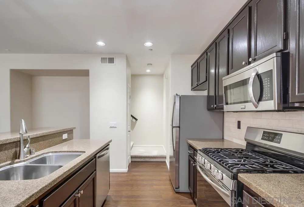 1298 Fools Gold Way, Unit 4 Chula Vista, CA 91913 - Photo 11 of 38 a kitchen with stainless steel appliances granite countertop a sink stove and refrigerator