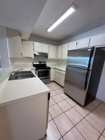 a kitchen with a stove top oven and cabinets